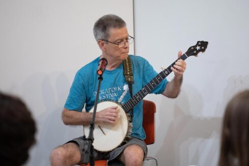 Older gentleman playing the banjo during open mic night