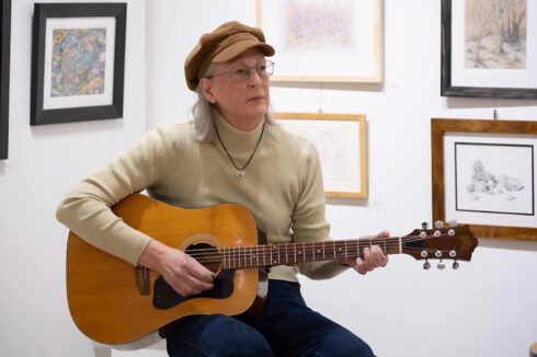Image showing a musician playing an acoustic guitar during open mic night