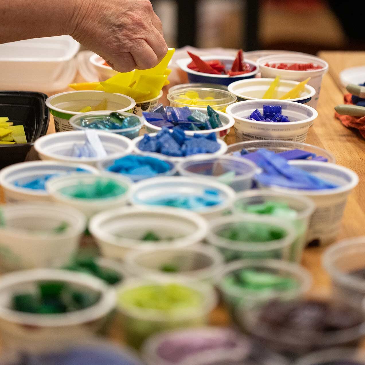 Close up of several pieces of mosaic glass sorted by colors